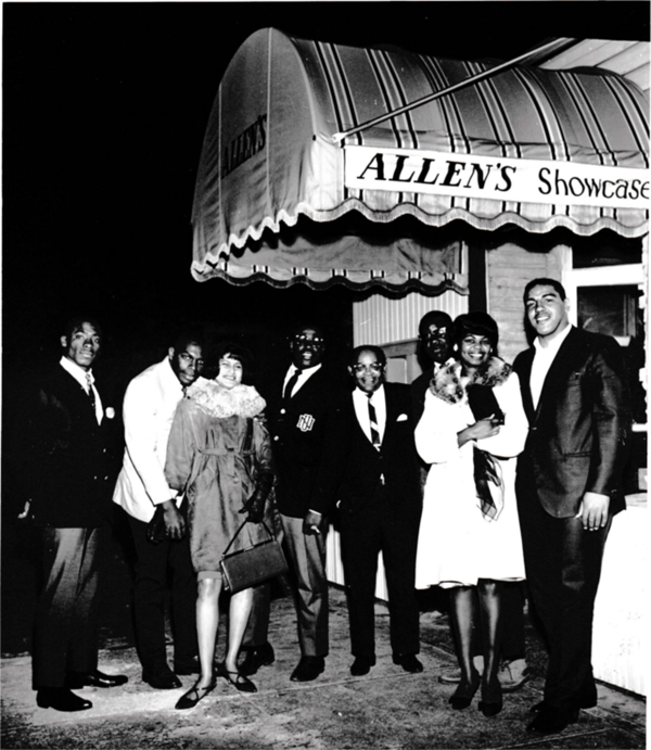 A group of well-dressed people stand in front of Allen's Showcase